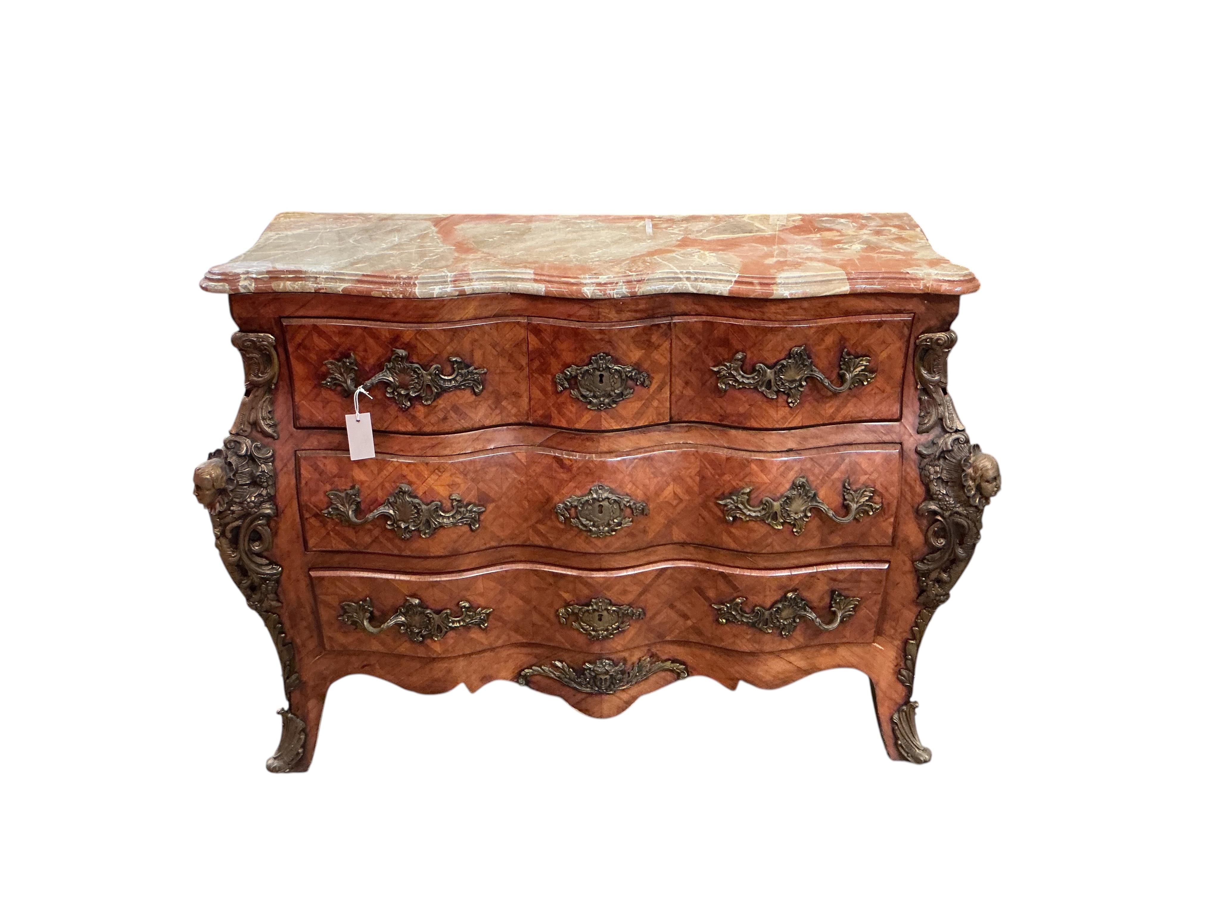 A French transitional style gilt metal mounted onyx top bombe commode, width 114cm, depth 47cm, height 88cm